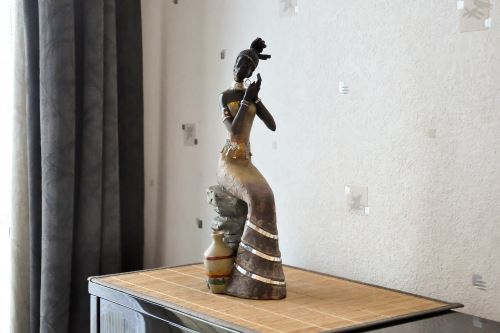 Statue femme africaine assise sur un rocher - noir
